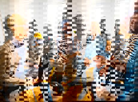 A group of people sitting in a circle in an office, talking about their mental health and checking in with each other